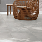 Brisa White Stone-effect Tile styled in a modern patio area with wooden rattan chair and natural light.