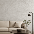 Living room interior featuring Celeste Grey Endless Marble Gloss Tiles on the wall, styled with a neutral beige sofa, black floor lamp, and round wooden coffee table with minimalist decor.