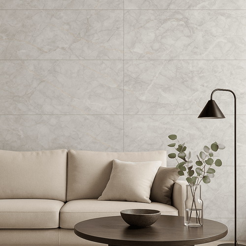 Living room interior featuring Celeste Grey Endless Marble Gloss Tiles on the wall, styled with a neutral beige sofa, black floor lamp, and round wooden coffee table with minimalist decor.