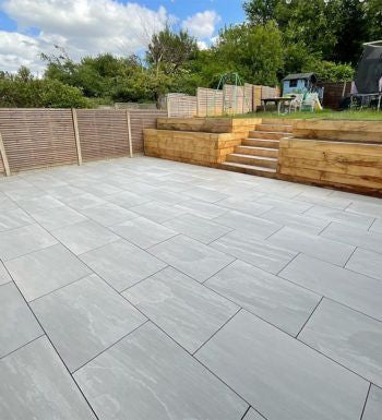Classic grey outdoor porcelain paving tiles 900x600mm laid on modern UK patio