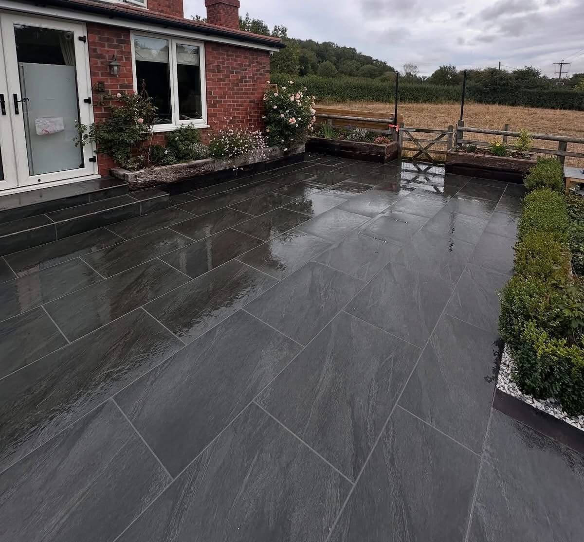 Dark anthracite premium outdoor porcelain paving tiles 900x600mm on sophisticated patio