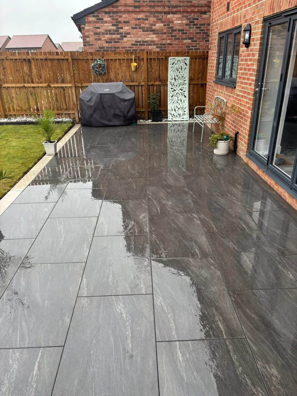 Deep charcoal stone effect outdoor porcelain paving tiles 900x600mm on sleek patio