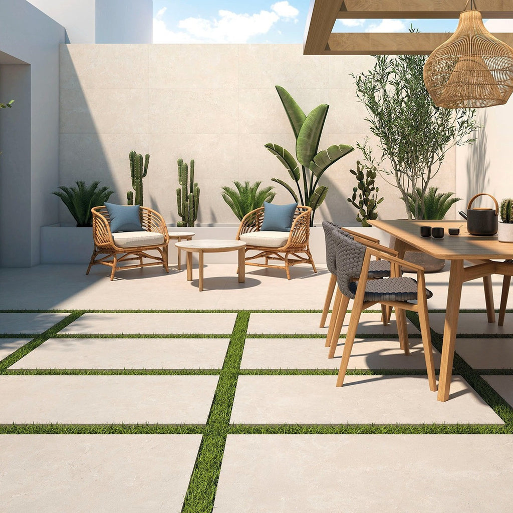 Solstice Beige Outdoor Tile used in a sunny garden seating area with outdoor furniture and green planting.