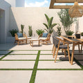Solstice Beige Outdoor Tile used in a sunny garden seating area with outdoor furniture and green planting.