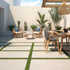 Solstice Beige Outdoor Tile used in a sunny garden seating area with outdoor furniture and green planting.