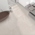 Modern bathroom with Dune Cream Stone Effect Tiles used across floor and wall, styled with a freestanding tub and wall-hung vanity.