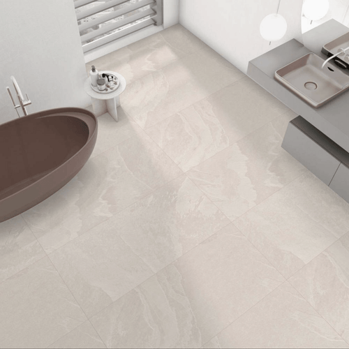 Modern bathroom with Dune Cream Stone Effect Tiles used across floor and wall, styled with a freestanding tub and wall-hung vanity.