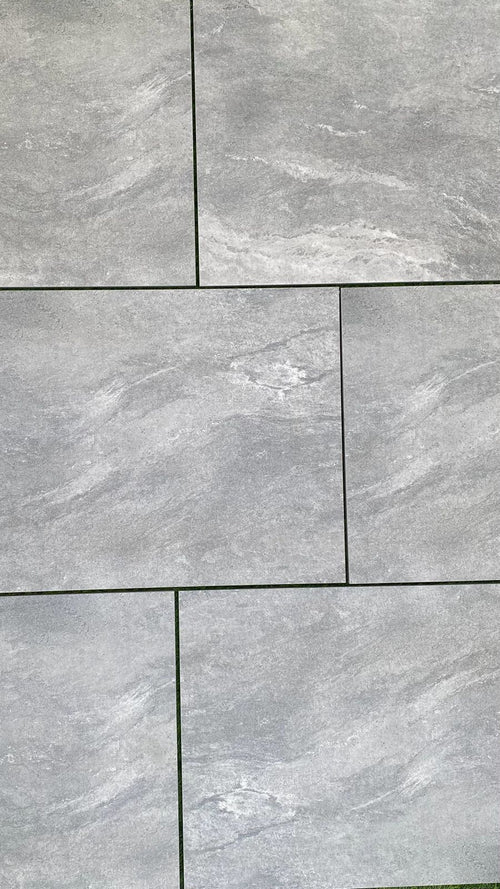 Cloudstone mid grey outdoor porcelain paving tiles 900x600mm laid on a modern UK garden patio