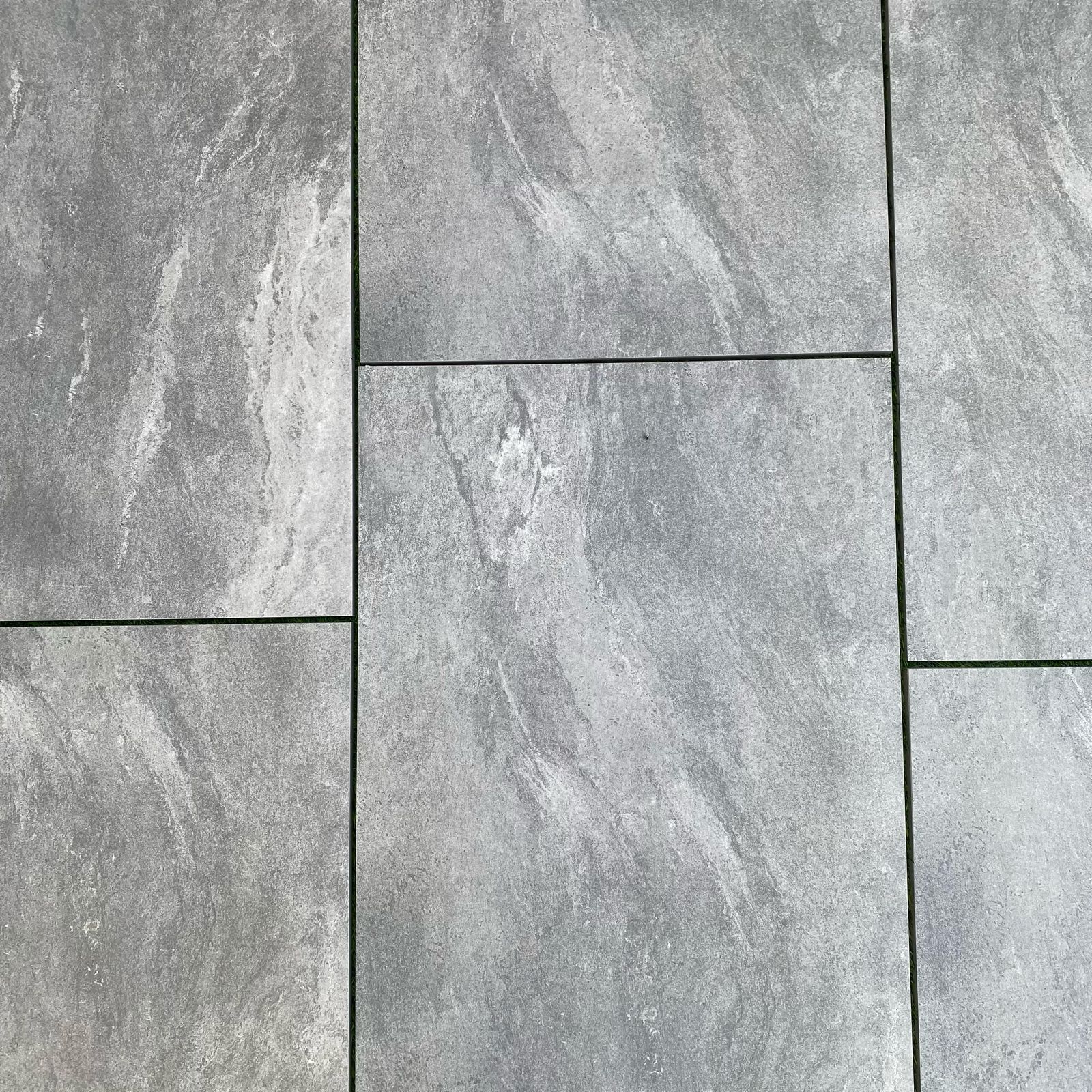 Mid grey speckled porcelain paving slabs 900x600mm in a landscaped garden terrace