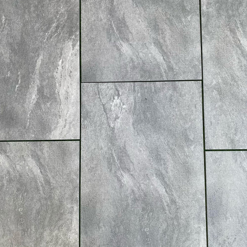 Mid grey speckled porcelain paving slabs 900x600mm in a landscaped garden terrace