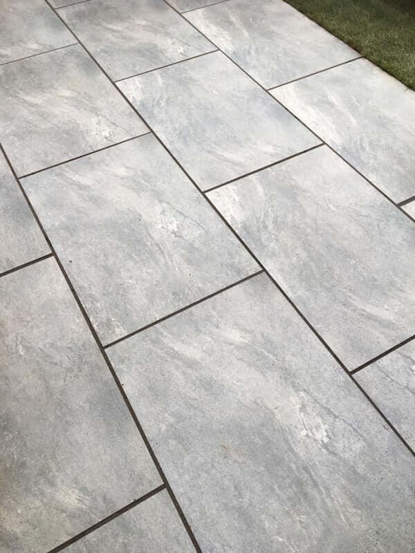 Smooth EC grey outdoor porcelain paving tiles 900x600mm on clean modern patio