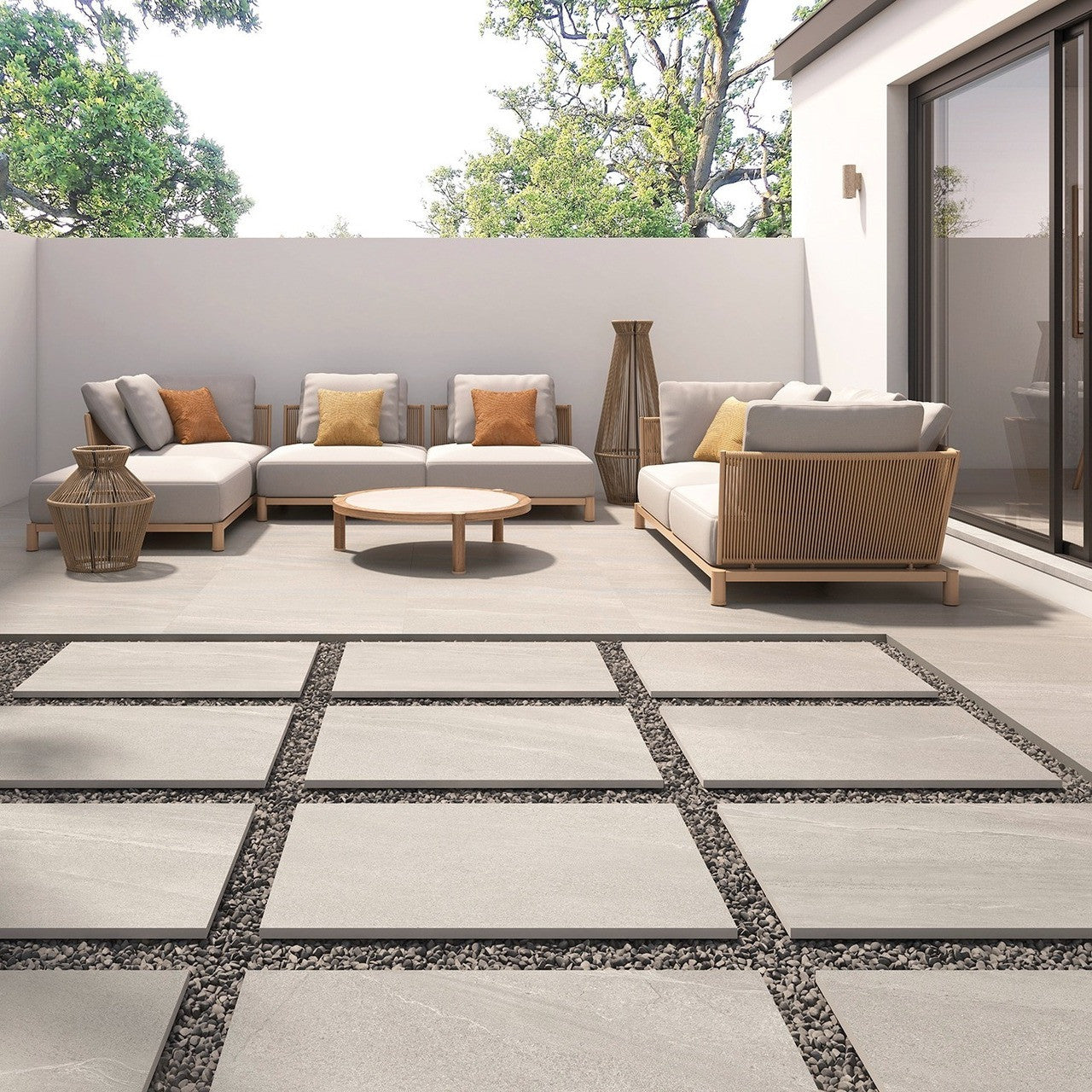 Gravel White Outdoor Tile used on a spacious patio with modern garden furniture and raised seating area.