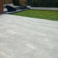 Grey hammered stone effect outdoor porcelain paving tiles 900x600mm on patio