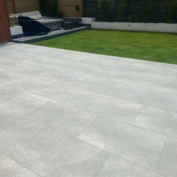 Grey hammered stone effect outdoor porcelain paving tiles 900x600mm on patio