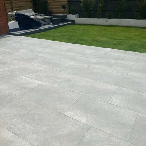Grey hammered stone effect outdoor porcelain paving tiles 900x600mm on patio