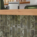 Vertical stacked installation of Oceania Green Tiles used as a bar or café counter front with natural oak accent.