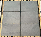 Jet black outdoor porcelain paving tiles 900x600mm on modern UK patio