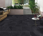 Newcastle black outdoor porcelain paving tiles laid in landscaped garden