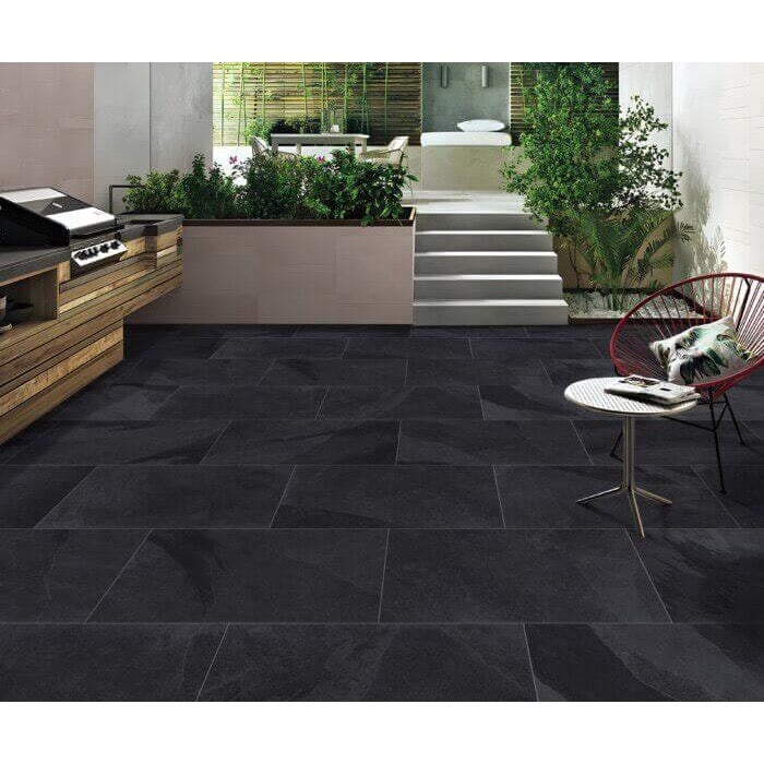 Newcastle black outdoor porcelain paving tiles laid in landscaped garden