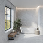 Modern bathroom featuring Lithos Grey Stone-effect tiles on walls and floors with natural light flooding through a black-framed window.